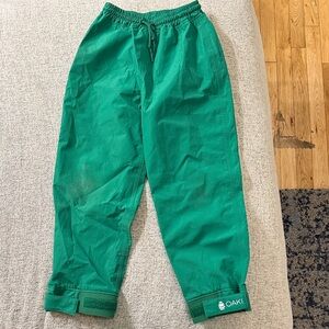 OAKI green rain pants with adjustable cuffs and drawstring waist